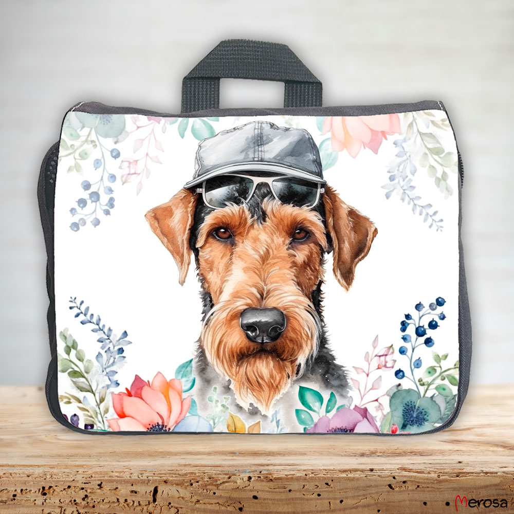 eine anthrazitfarbene Hundetasche mit mehreren Reißverschlussfächern, welche mit einem Airedale Terrier mit Brille und Hut und einer Blumenranke im fröhlich bunten Watercolor-Stil bedruckt ist