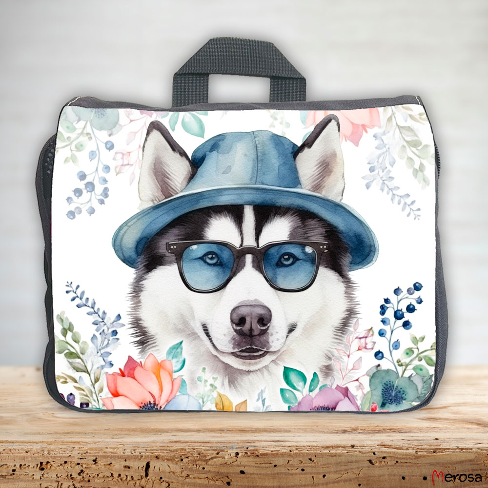 eine anthrazitfarbene Hundetasche mit mehreren Reißverschlussfächern, welche mit einem Husky mit Brille und Hut und einer Blumenranke im fröhlich bunten Watercolor-Stil bedruckt ist