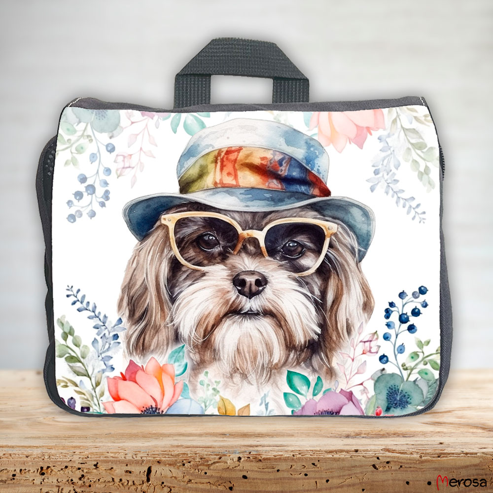 eine anthrazitfarbene Hundetasche mit mehreren Reißverschlussfächern, welche mit einem Havaneser mit Brille und Hut und einer Blumenranke im fröhlich bunten Watercolor-Stil bedruckt ist