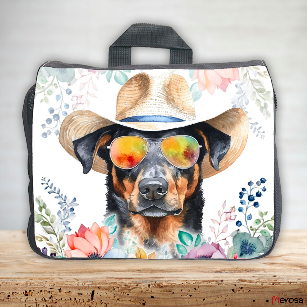 eine anthrazitfarbene Hundetasche mit mehreren Reißverschlussfächern, welche mit einem Beauceron mit Brille und Hut und einer Blumenranke im fröhlich bunten Watercolor-Stil bedruckt ist